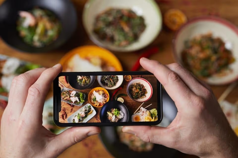 Close up of person taking photo of delicious food with a smartphone.