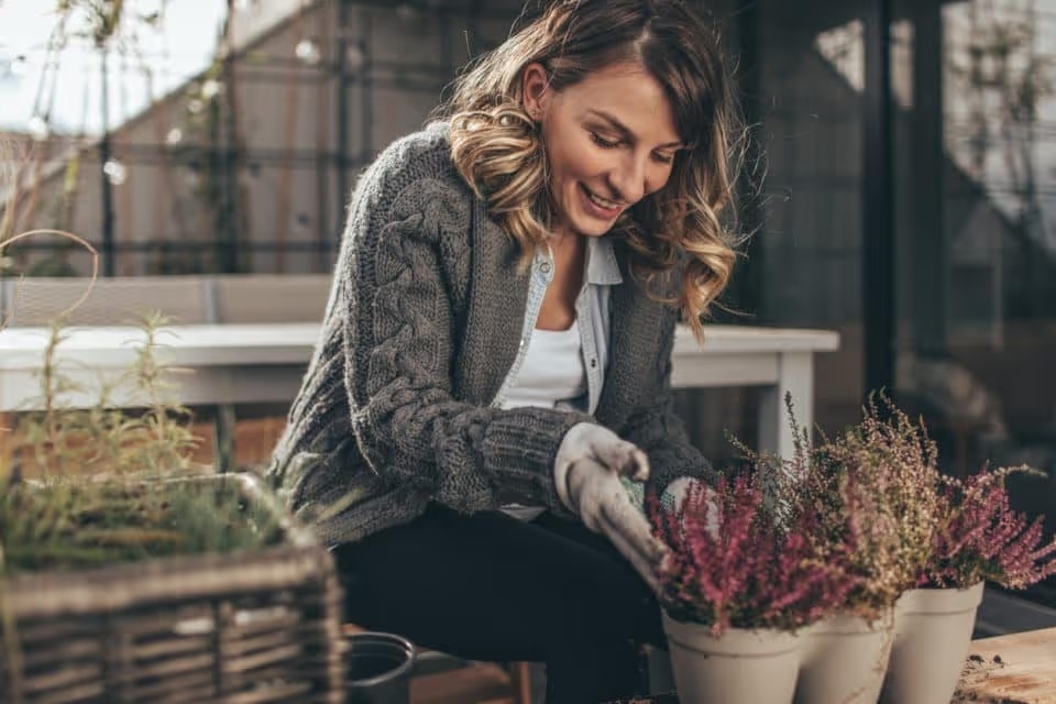 Photo of a young woman taking care of her garden on a beautiful autumn day