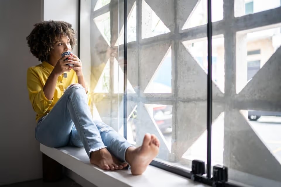 A young woman drinking coffee on a calm morning
