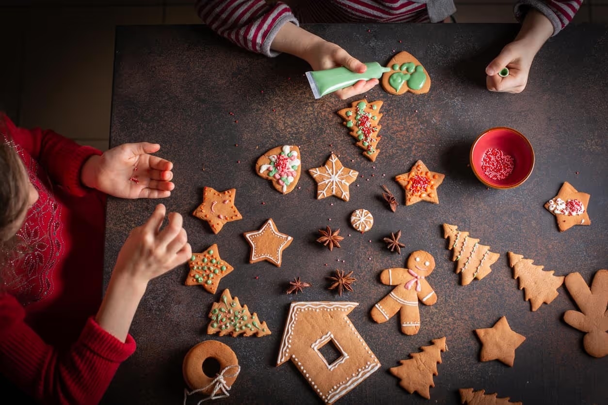 Little girls making Christmas gingerbread cookies.