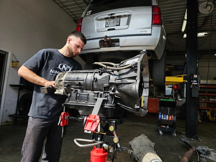 A current New Generation Cars technician working on a transmission