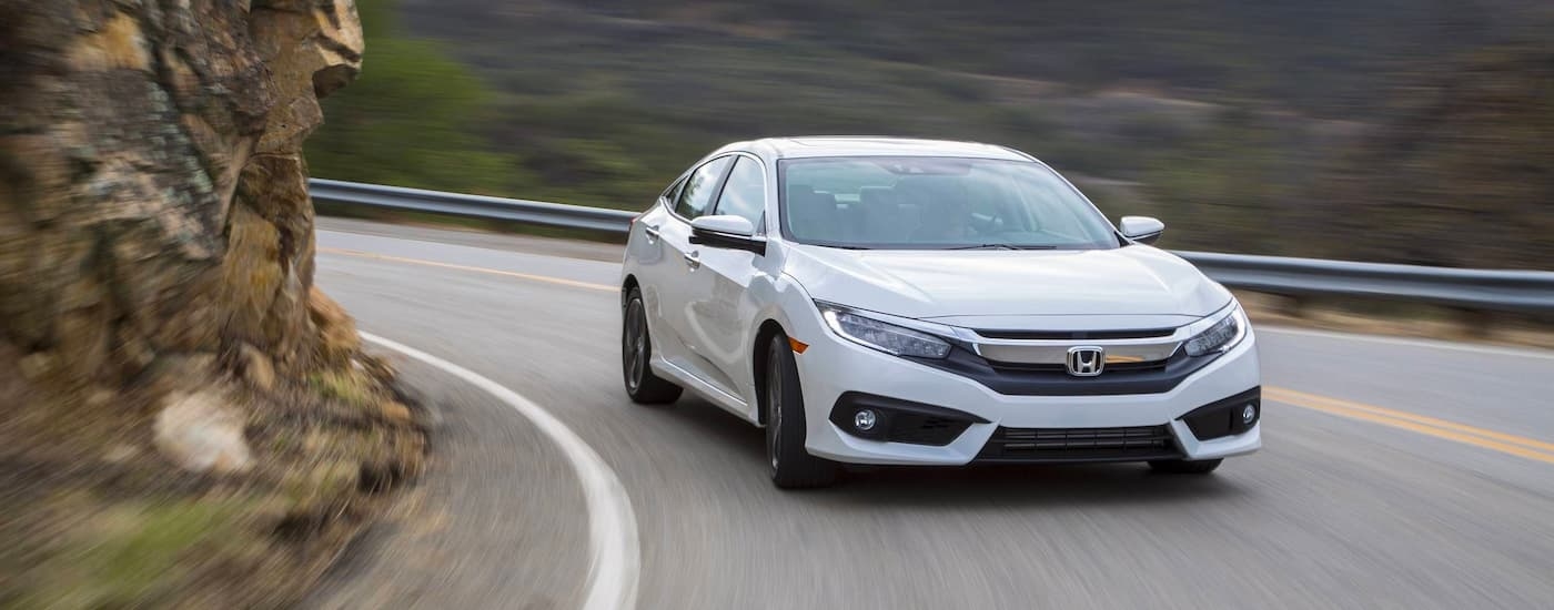 White 2017 Honda Civic driving around a bend.