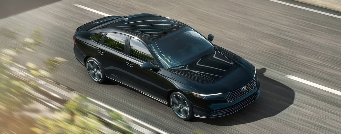 High view of a black 2026 Honda Accord driving down an open road.