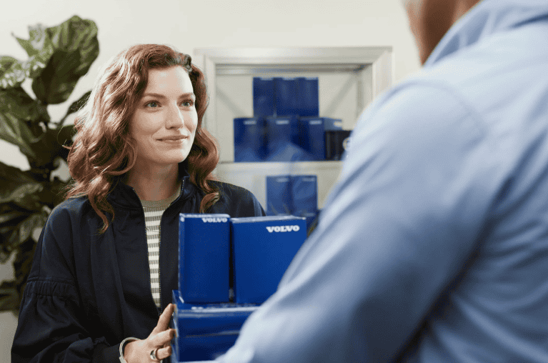 Woman handing stack of boxes to someone
