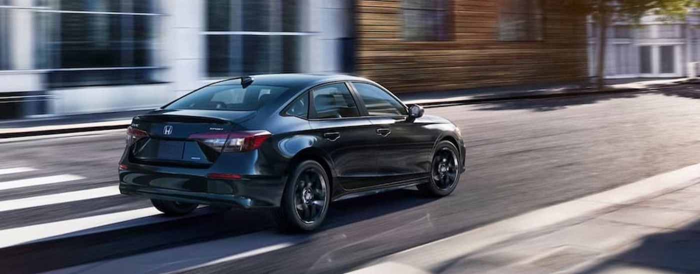 A black 2026 Honda Civic driving in a city.