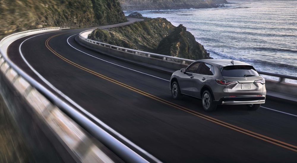 A silver 2027 Honda HR-V EX-L shown driving by the ocean.