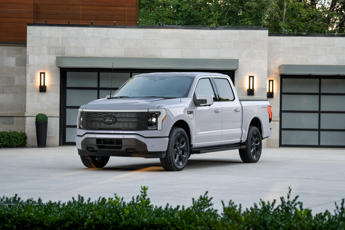 Ford F-150 Lightning electric pickup truck parked in front of a modern home.