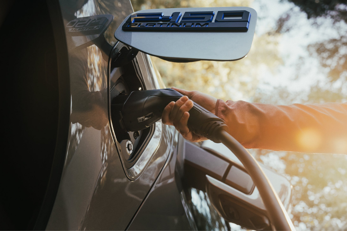 Ford F-150 Lightning being plugged into an electric vehicle charger.