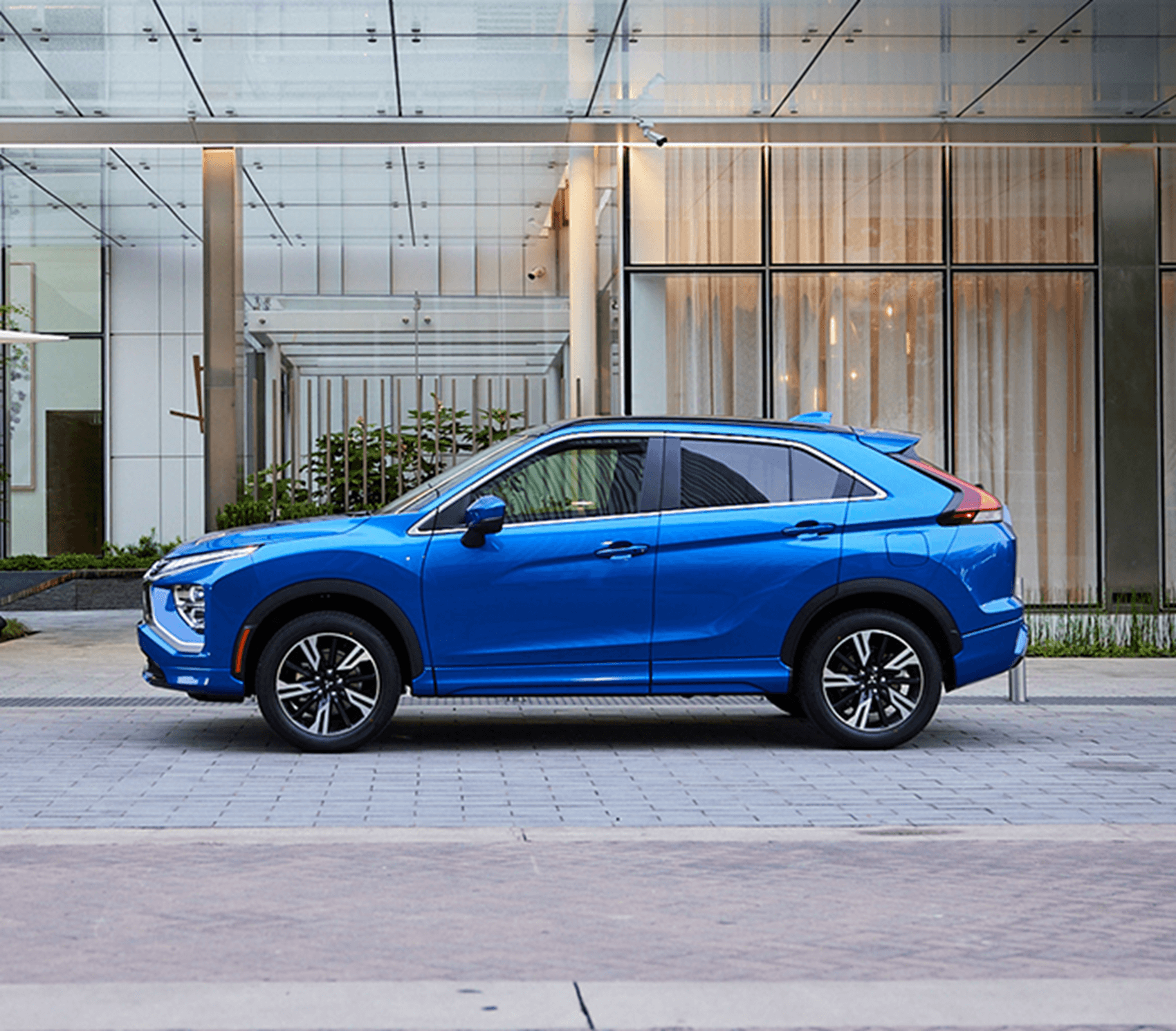 Blue Mitsubishi Outlander on road in front of building