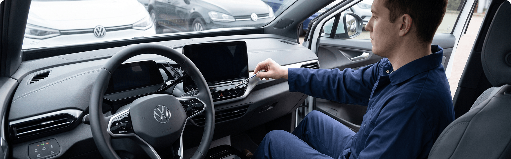 Technician checking the dashboard air vents from the driver's seat of a Volkswagen