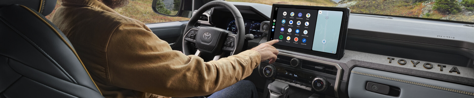 Driver cockpit view of a 2026 Toyota Tacoma Trailhunter featuring the 14-inch Toyota Audio Multimedia touchscreen.