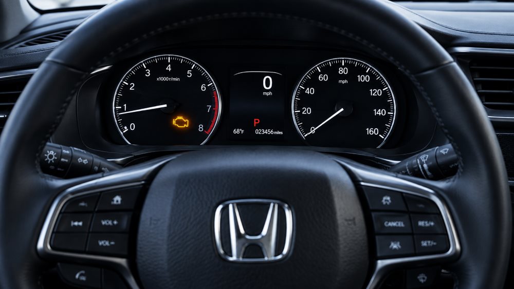 Honda dashboard showing an illuminated check engine light