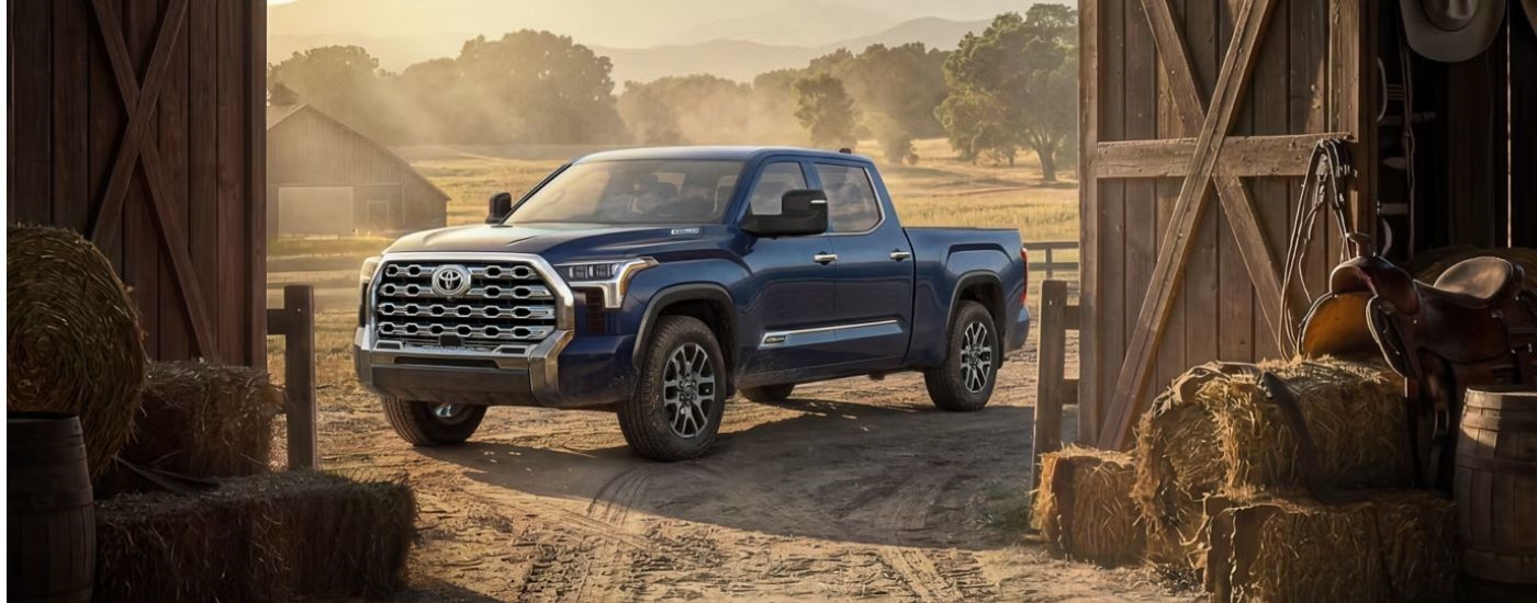 A blue 2026 Toyota Tundra 1794 Edition Hybrid CrewMax parked on a ranch.