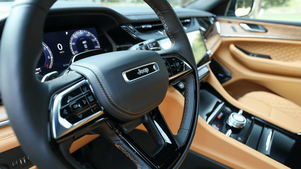 2026 Jeep Grand Cherokee steering wheel close-up in Margate FL with tan leather interior and digital cluster