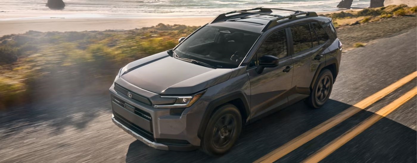 A silver 2026 Toyota RAV4 Woodland driving by the ocean.