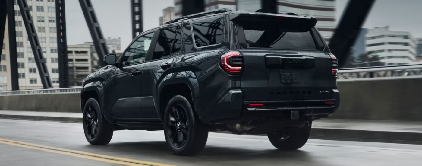 Rear view of a dark gray 2026 Toyota 4Runner platinum crossing a bridge.