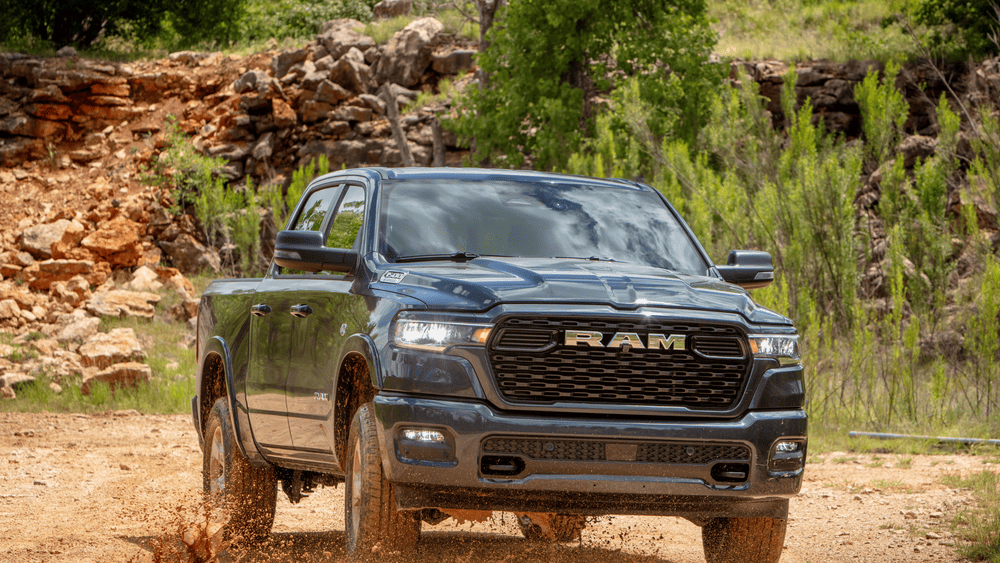 2026 Ram 1500 in gray with RAM grille kicking up mud — full-size truck duty near Margate FL