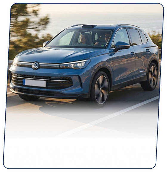 Blue Volkswagen SUV driving along a coastal highway