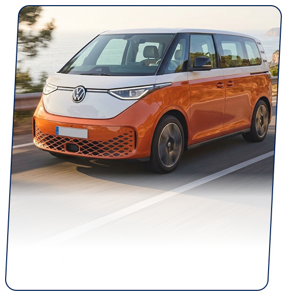 Orange and white Volkswagen electric van driving along a coastal highway