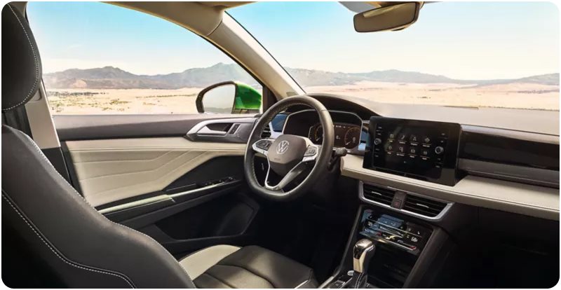 Volkswagen cabin with the steering wheel and touchscreen, desert hills visible through the windows