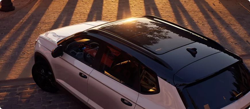 White Volkswagen Taos with a black roof and panoramic sunroof, seen from above in evening light
