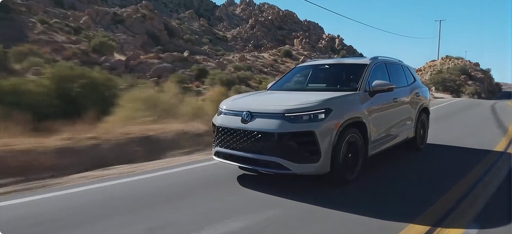 Silver 2026 Volkswagen Tiguan driving along a desert highway