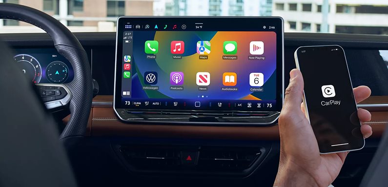 Apple CarPlay on the Volkswagen Tiguan touchscreen next to a phone showing CarPlay