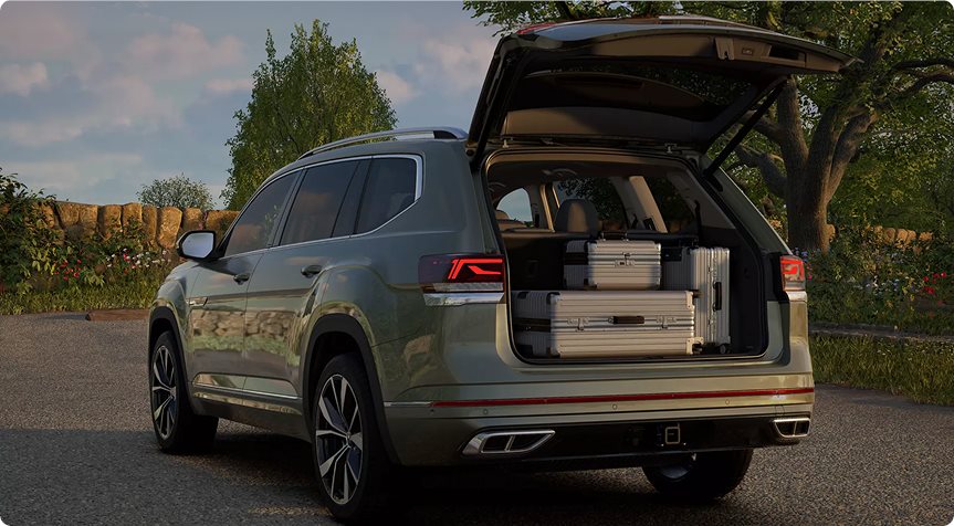 Green Volkswagen Atlas with the liftgate open and luggage loaded in the cargo area