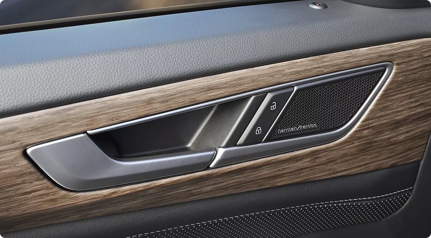 Wood-trimmed door panel with a Harman Kardon speaker in the Volkswagen Atlas