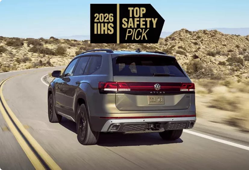 Silver Volkswagen Atlas driving on a desert road beside a 2026 IIHS Top Safety Pick badge