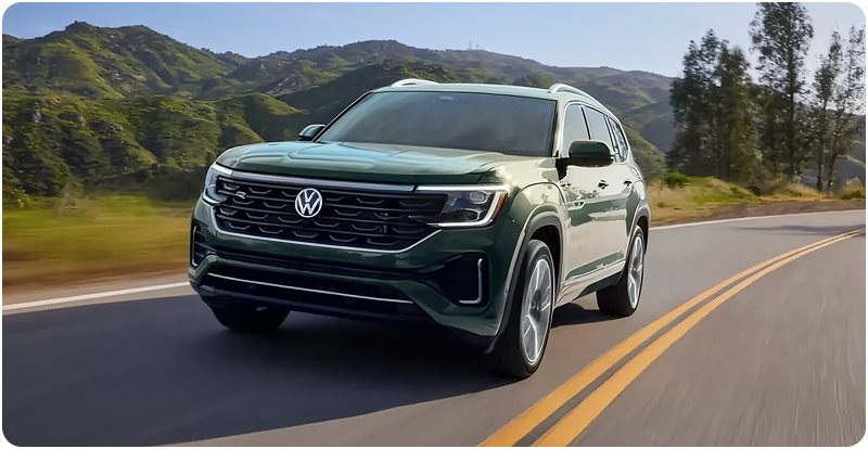 Green Volkswagen Atlas driving on a winding mountain road