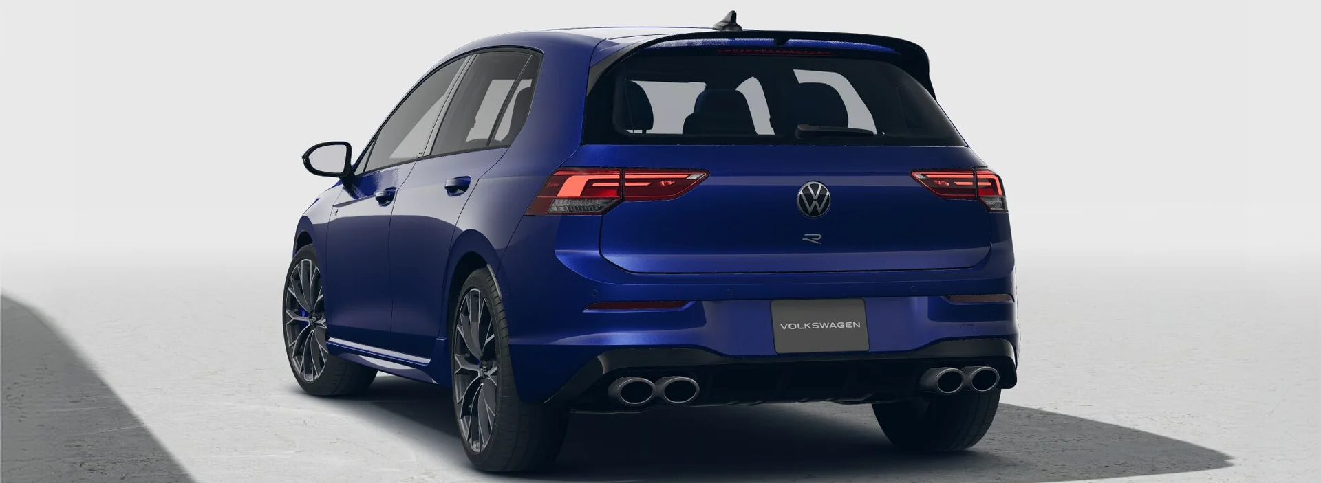 Rear three-quarter view of a blue Golf R showing its quad exhaust tips