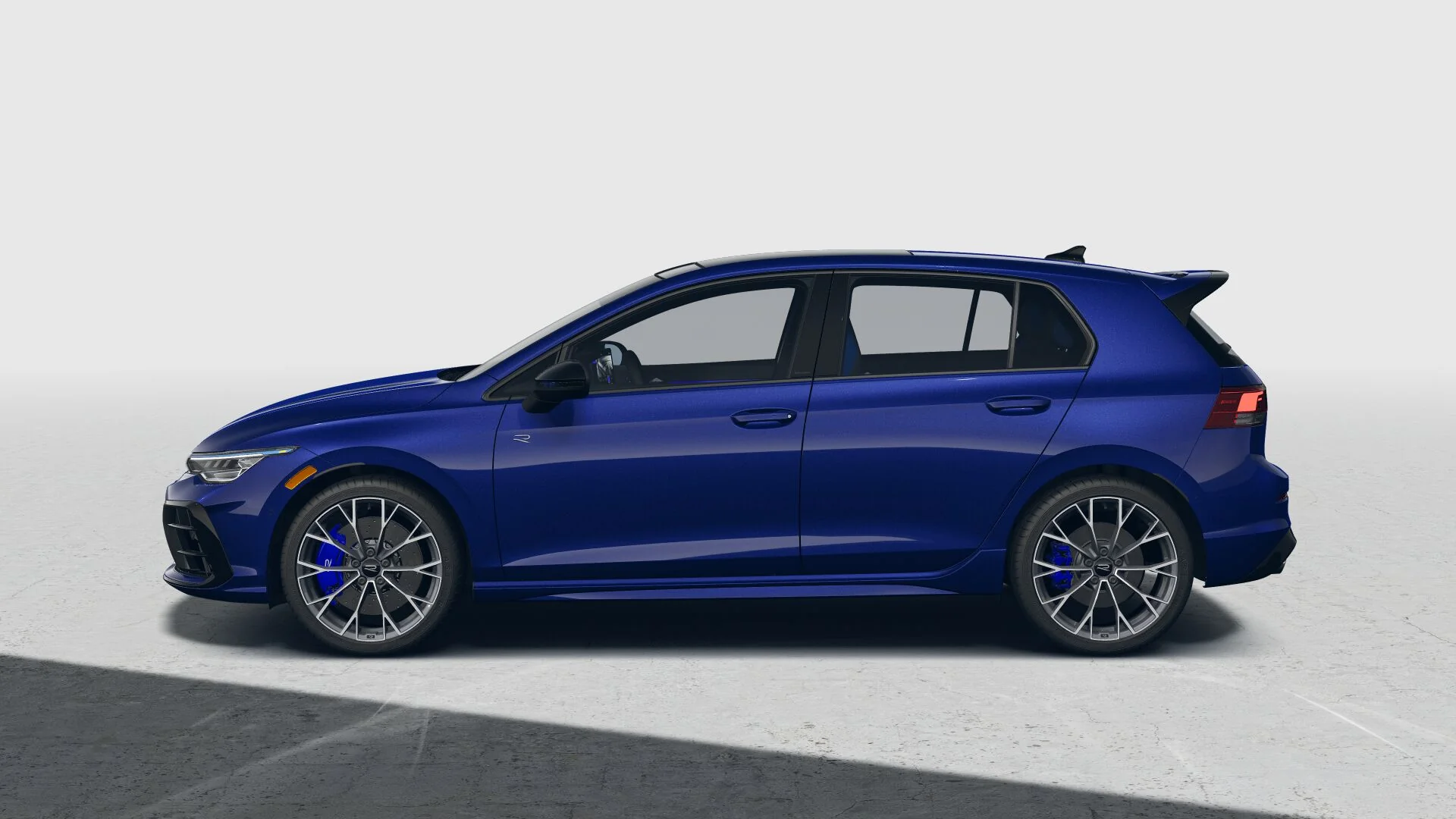 Side view of a blue Golf R on a light gray backdrop