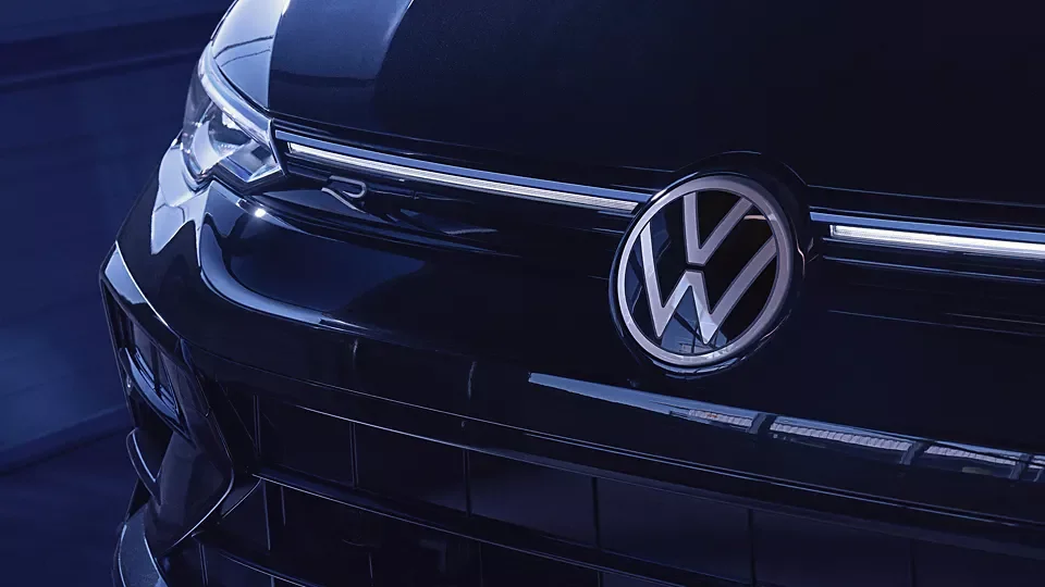 Illuminated VW logo and grille light bar on a dark blue Golf R
