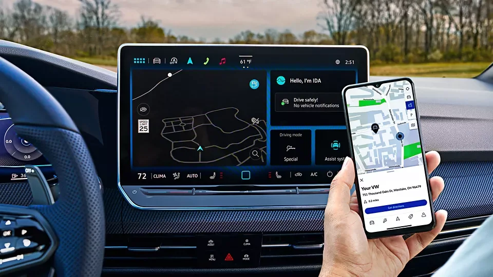 Passenger holding a smartphone with a map beside the Golf R touchscreen