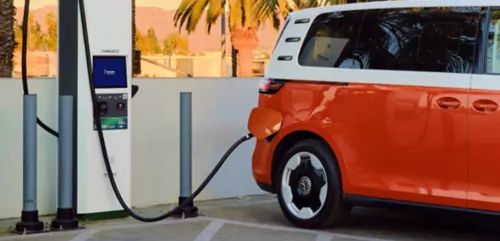 Red and white ID. Buzz plugged in at an Electrify America charging station