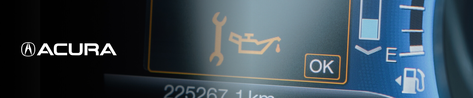 A close-up of a vehicle's dashboard lights showing a wrench and an oil can and the words Oil Change Required.