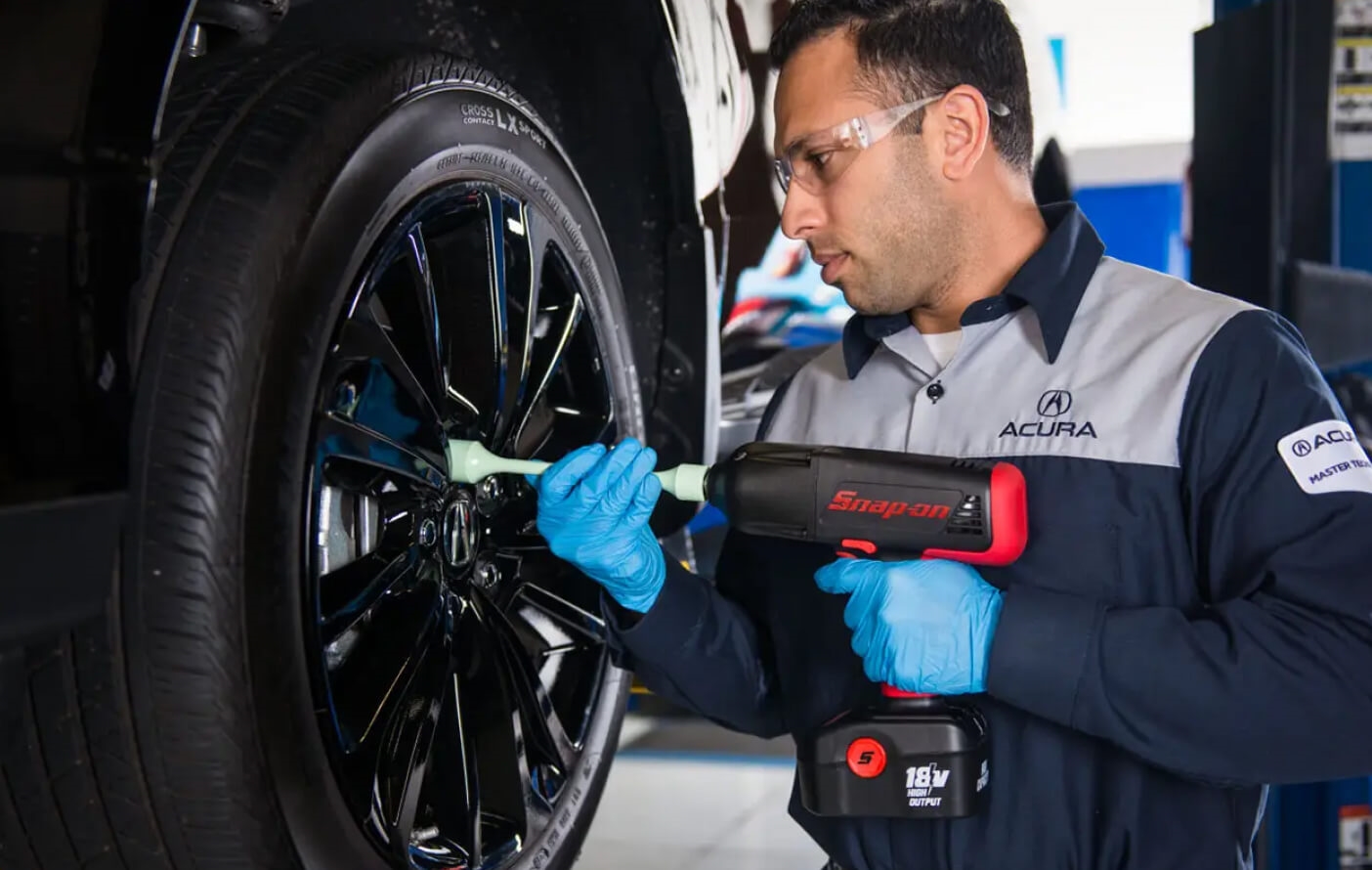 A close-up shot of an Acura Service Technician tightening the lugs on an Acura vehicle's wheels with a torque wrench.
