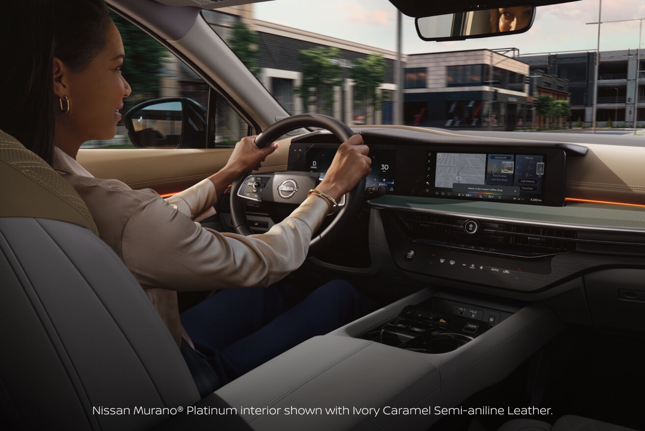 Interior view of a woman driving a 2027 Nissan Murano Platinum with Ivory Caramel Semi-Aniline Leather interior.