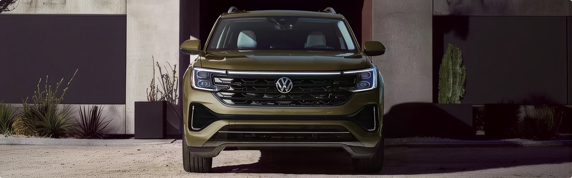Green 2026 Volkswagen Atlas parked in front of a modern building