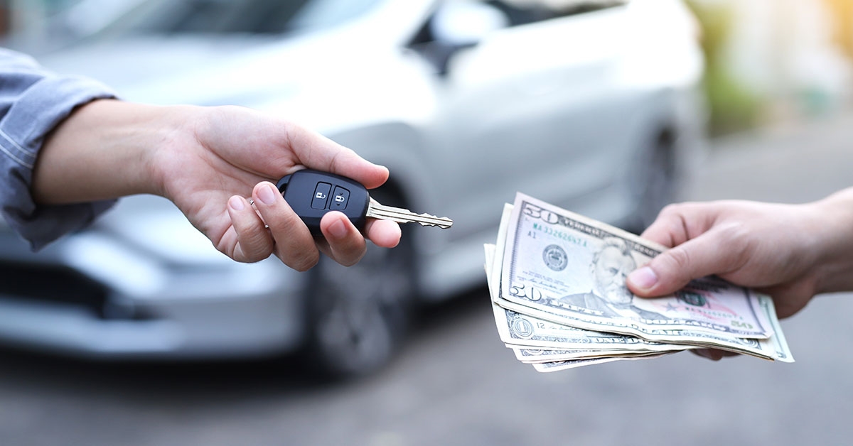 Cash and keys exchanging hands as part of Subaru trade-in