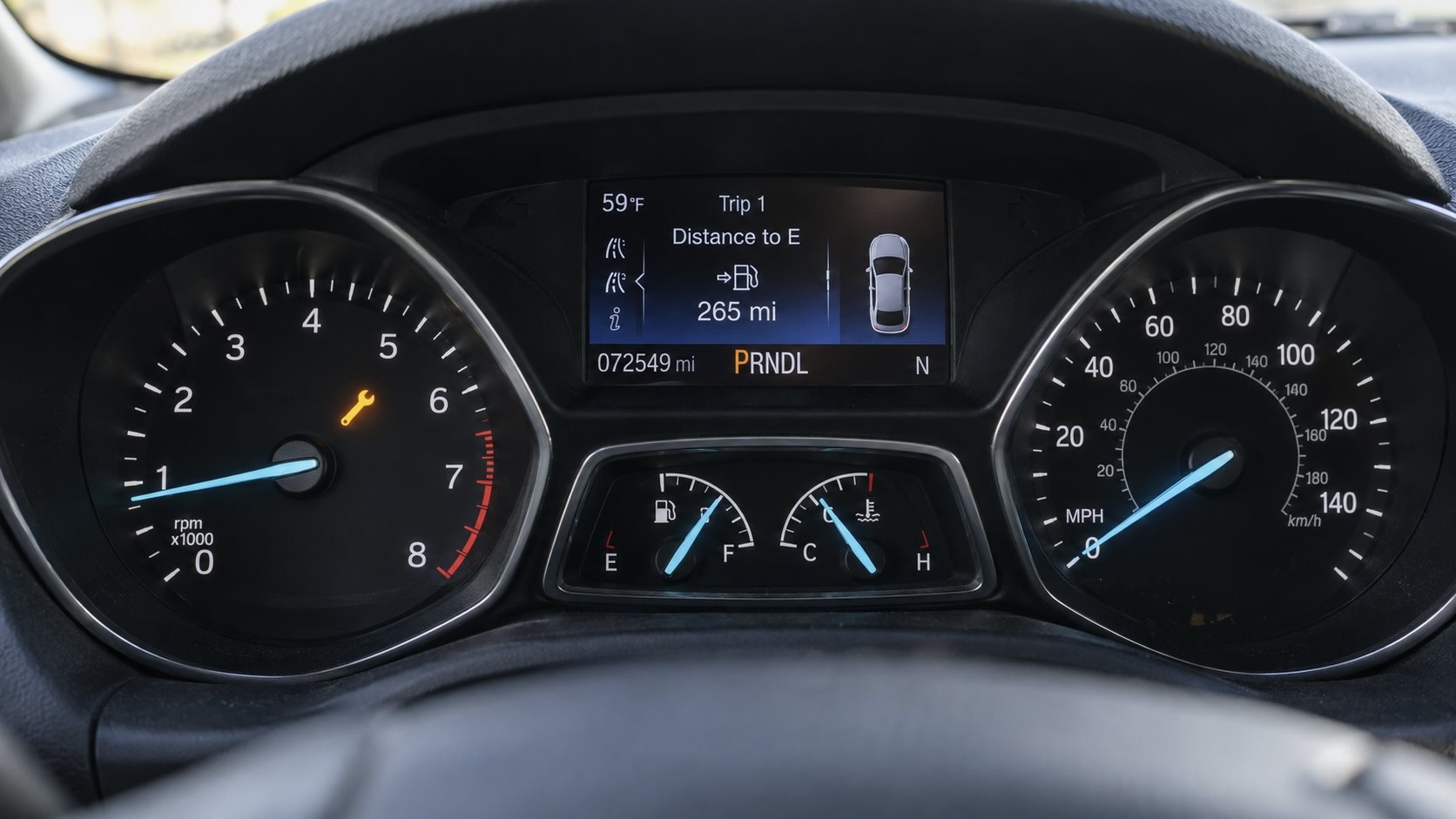 Ford Escape instrument cluster with the amber powertrain fault wrench symbol lit next to the speedometer.