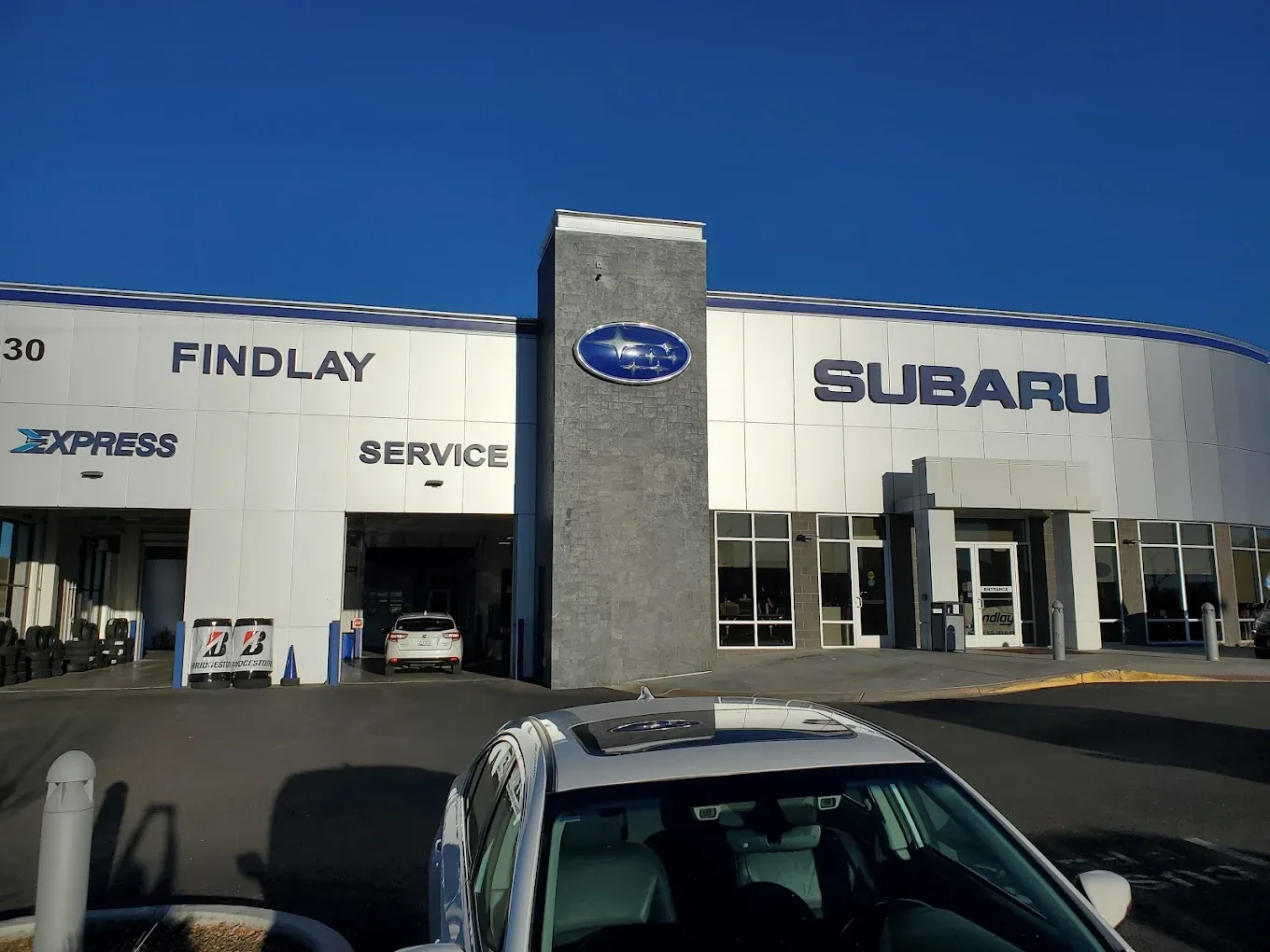 The service entrance at a Findlay Subaru dealership, with a Subaru parked outside the service bays.
