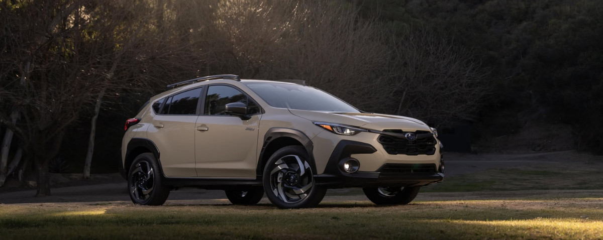 A Subaru Crosstrek parked on a grass clearing at golden hour, the everyday miles that set its next scheduled service.