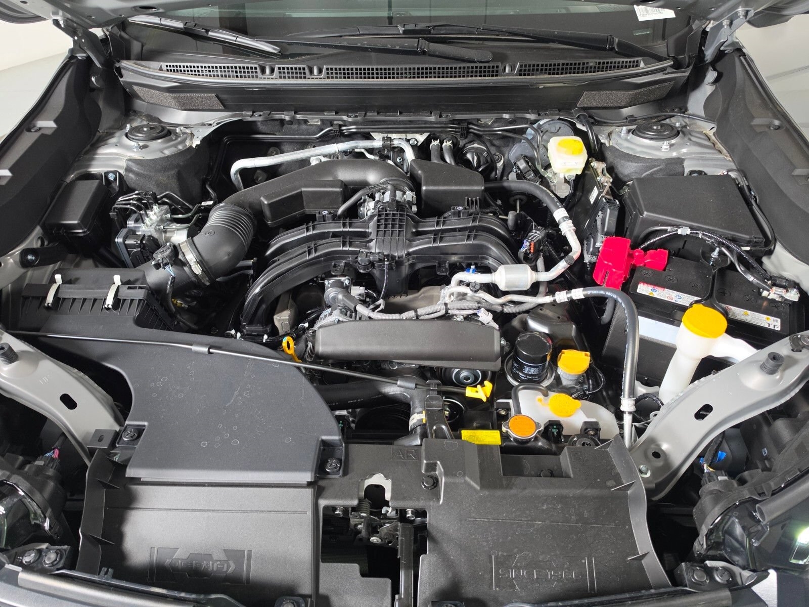 The engine bay of a Subaru Outback with the hood raised