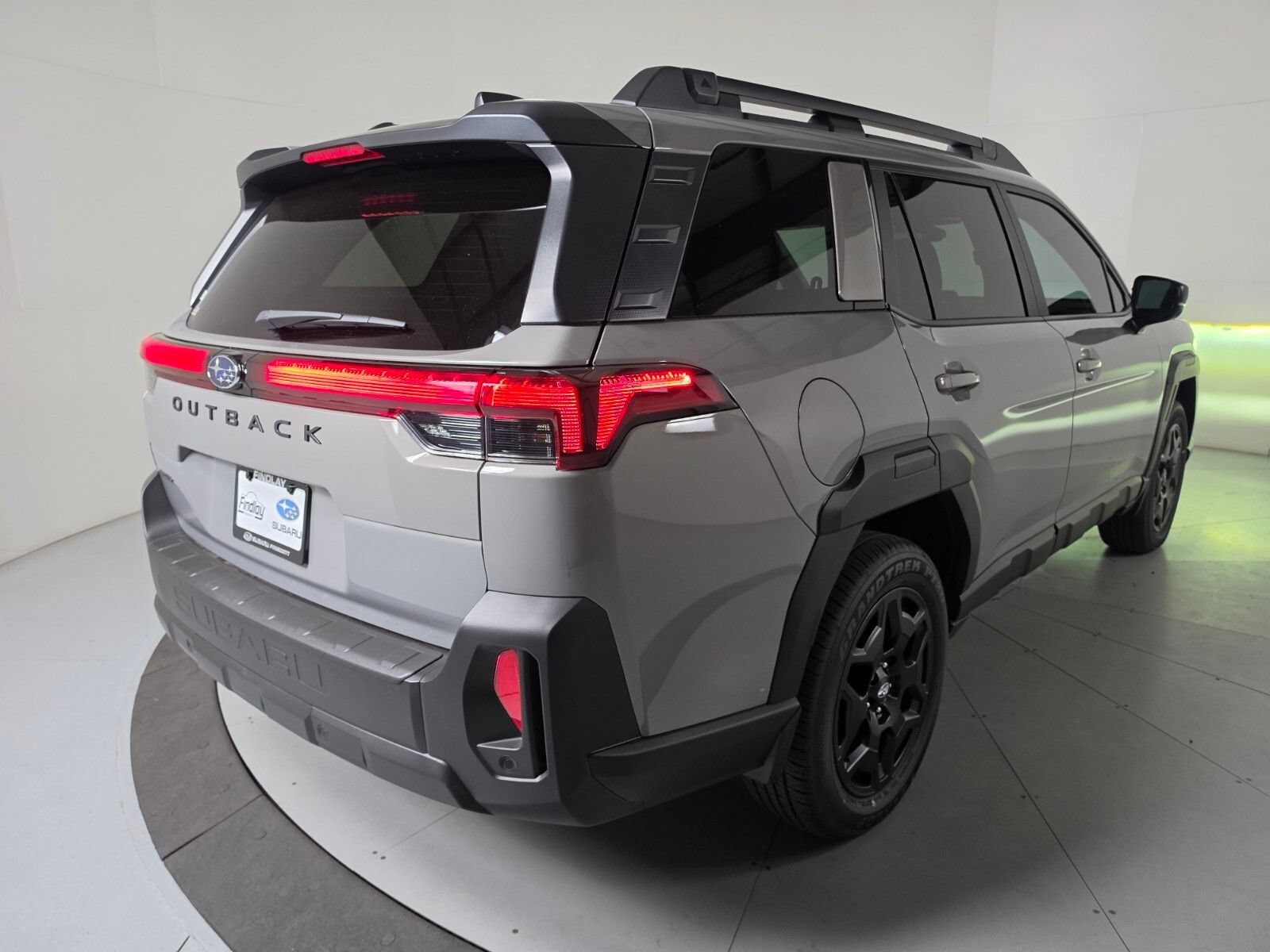 Rear three-quarter view of a grey Subaru Outback in the studio