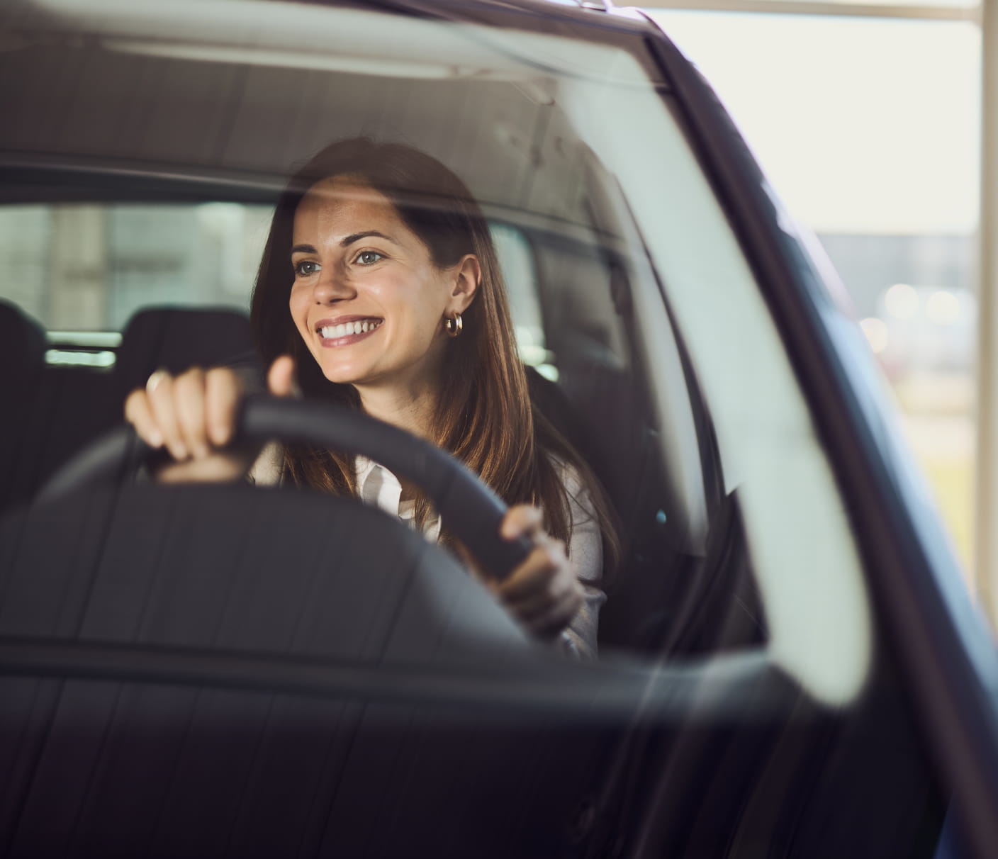 Smiling woman driving a vehicle.