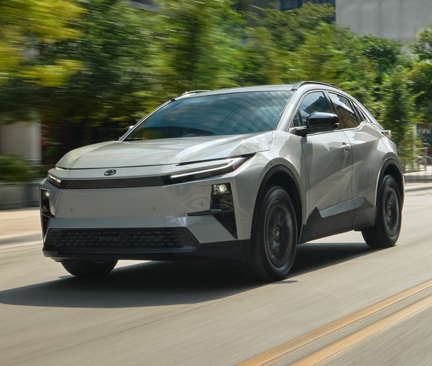 Silver electric SUV driving on a city street.