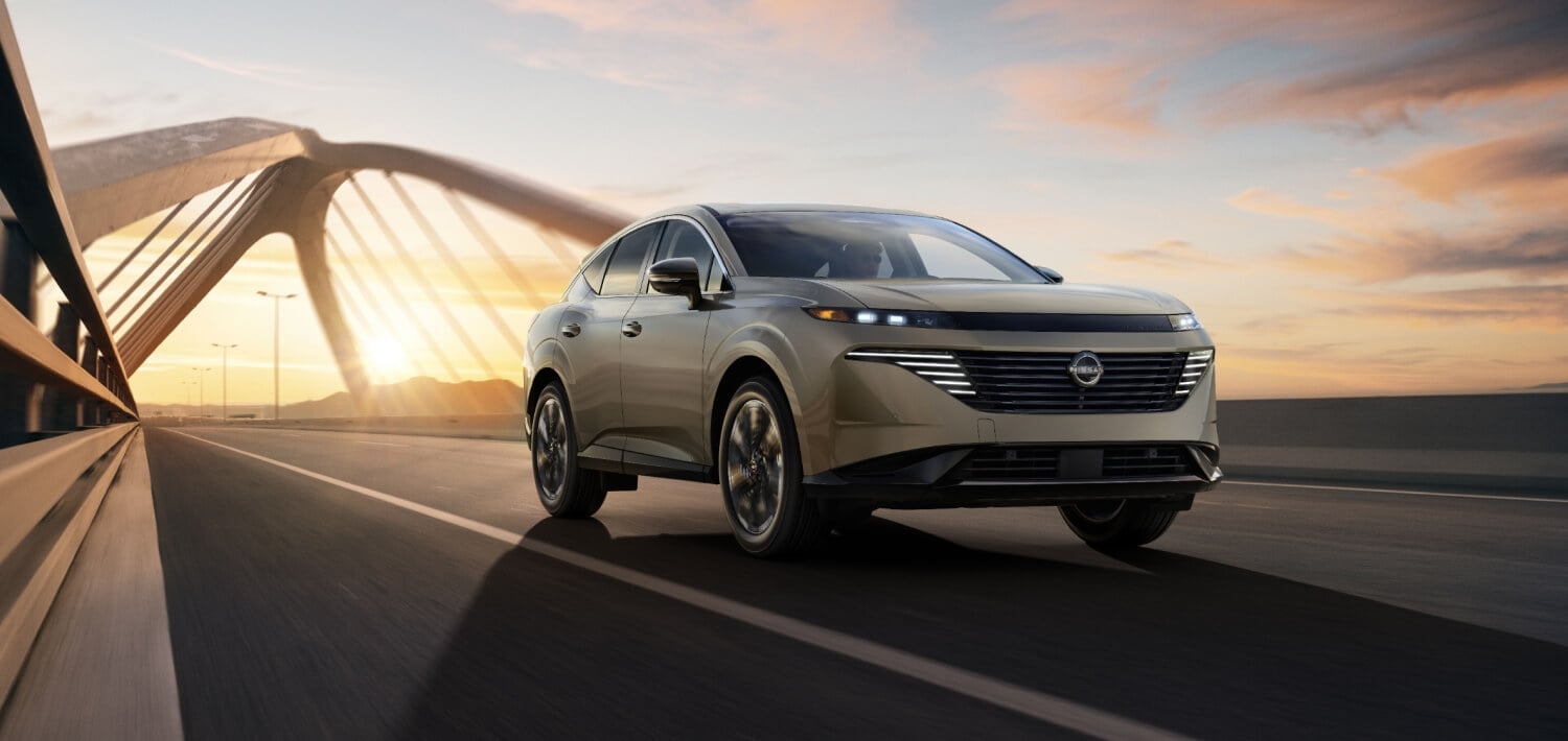 2027 Nissan Murano on a city bridge at sunset, viewed from the front three-quarter angle.