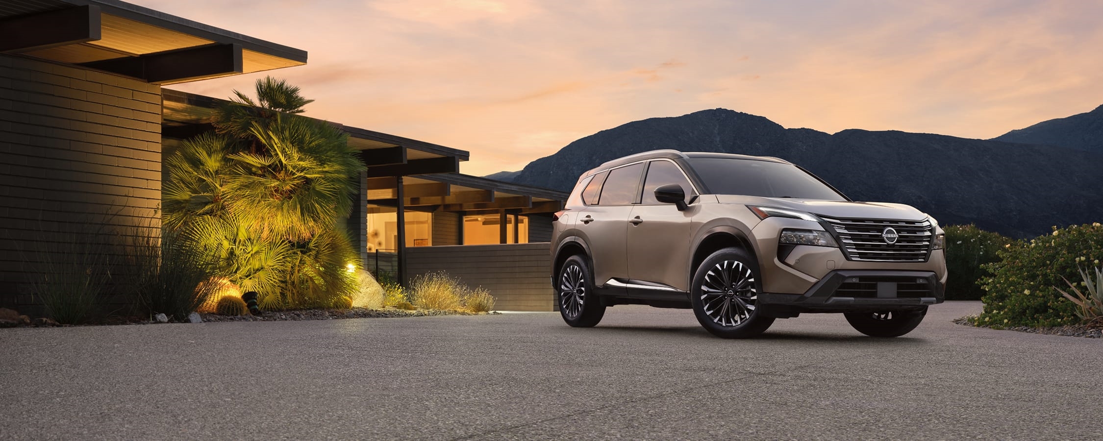 2026 Nissan Rogue parked in front of a house in the desert dusk